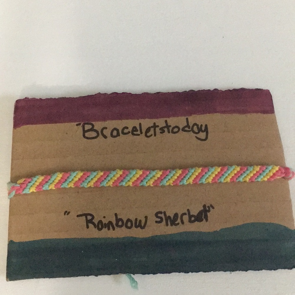 A striped styled bracelet made of cotton thread.